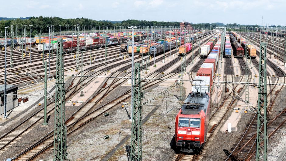Nowoczesny terminal przeładunkowy z widocznymi kontenerami i suwnicami