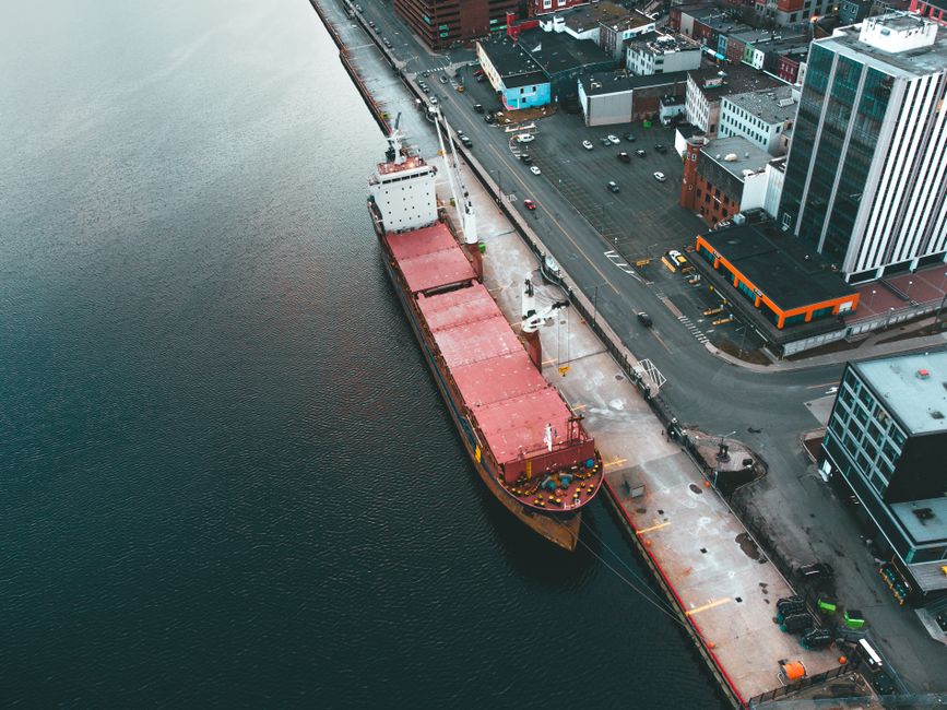 Statek transportowy w porcie przeładowujący kontenery z ładunkami zbiorczymi